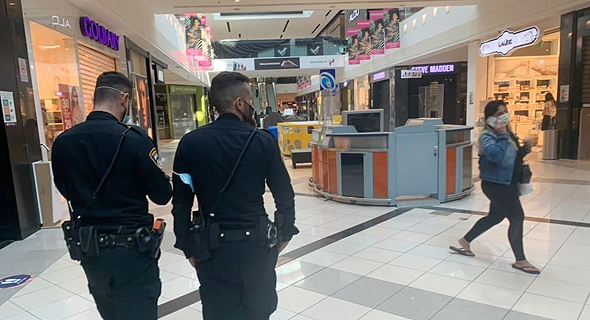 שוטרים בחנויות בקניון עם חנויות שפתחו למרות ההנחיות