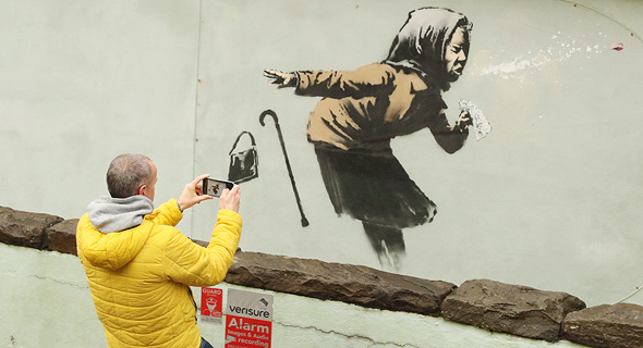 ילדה מתעטשת. ציור קיר של הצייר אמן בנקסי , צילום: איי אף פי