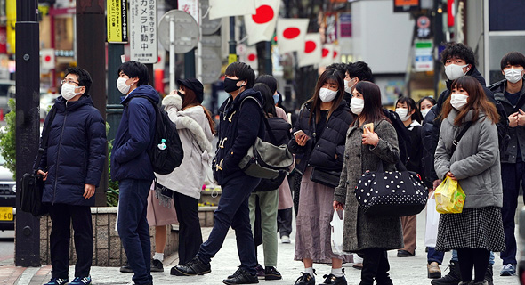 תושבים בטוקיו עם מסכות, צילום: איי פי