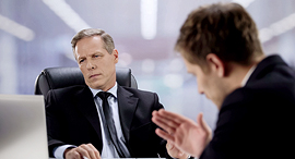 A manager looking at figures while enjoying his employee. Photo: shutterstock