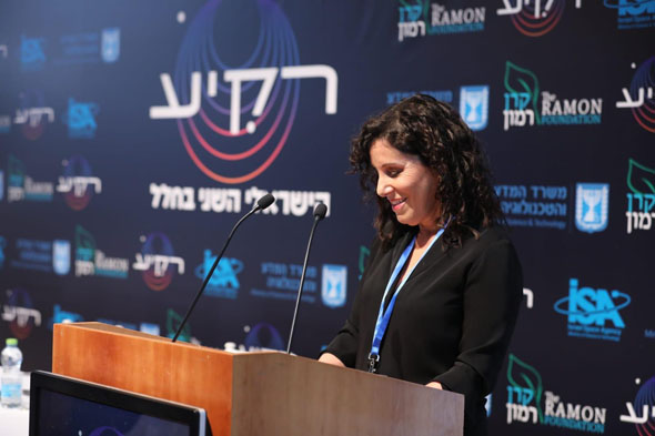 Inbal Kreiss, who will oversee the experiments that the next Israeli astronaut will take with him to the ISS speaks at a conference. Photo: Ramon Foundation