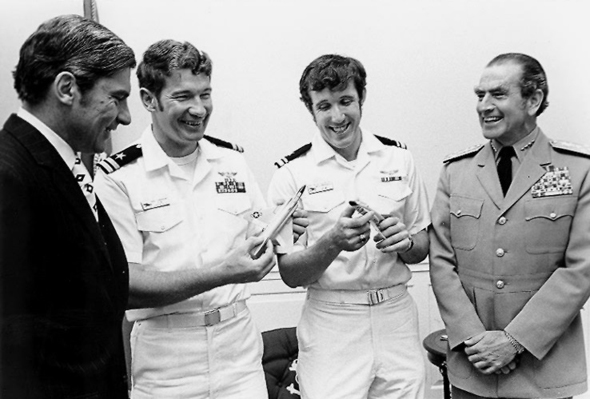 מימין: אדמירל אלמו זומוולט, הגיבורים דריסקול וקמינגהאם, ושר הימייה ג'ון וולטר בביקור במשרדו בוושינגטון 