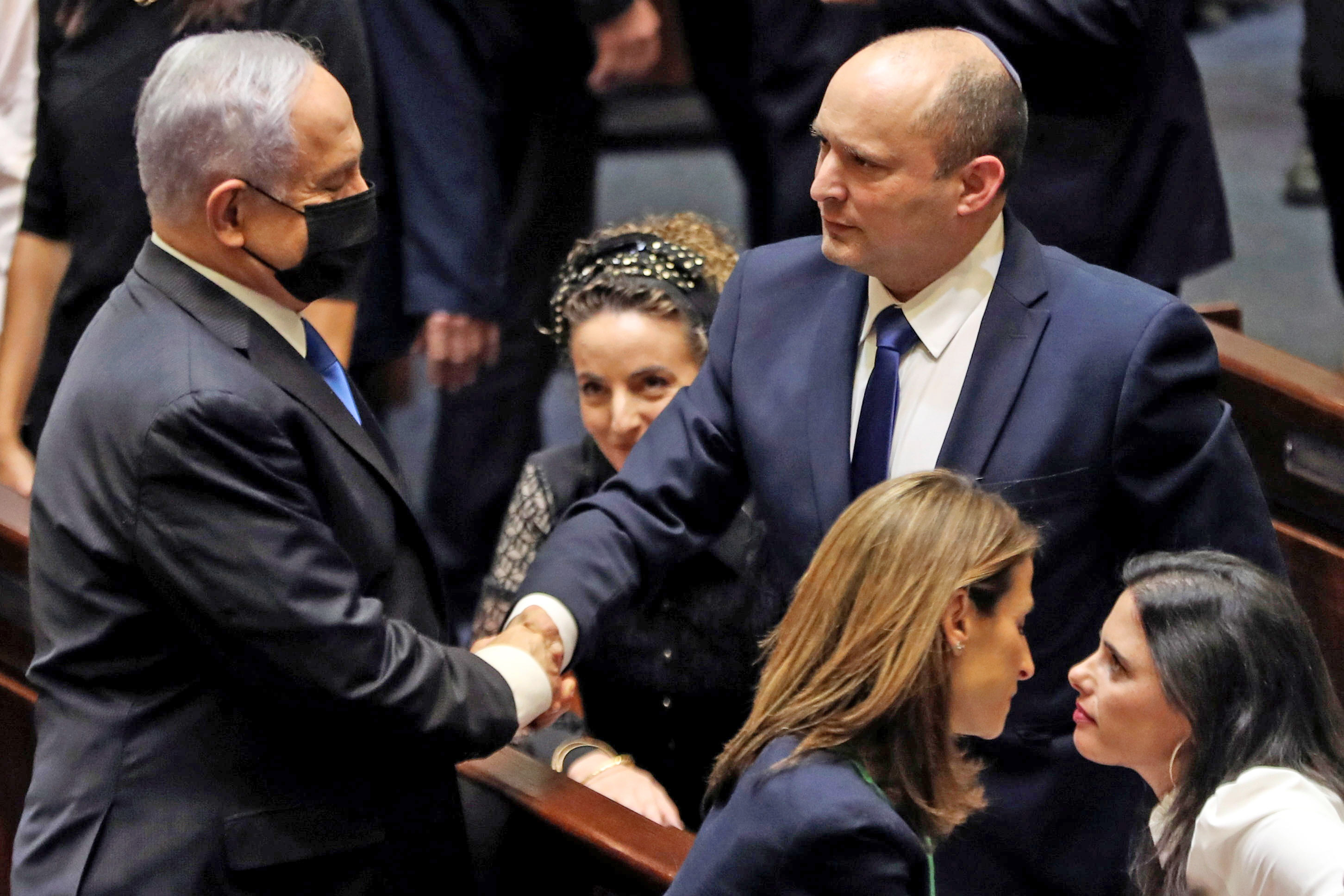 Incoming Prime Minister Naftali Bennett (right) shakes hands with Benjamin Netanyahu. Photo: Reuters