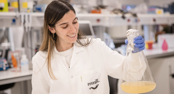 Lab technician Maya Danino holds up Remilk's alternative milk. Photo: Tal Zelicovitch