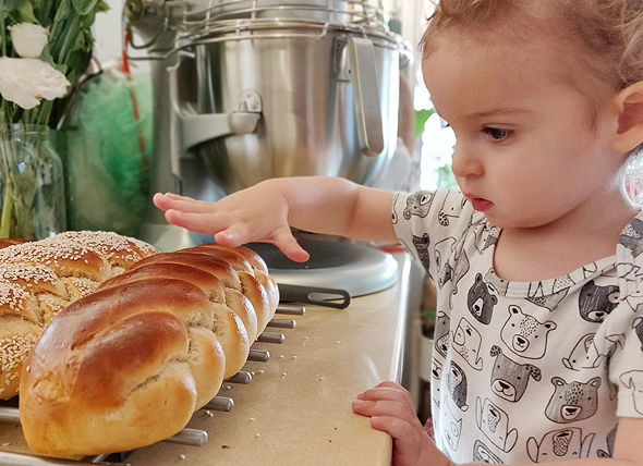 Photo: Assaf Lavi&#39;s child and a freshly baked bread. Photo: Courtesy