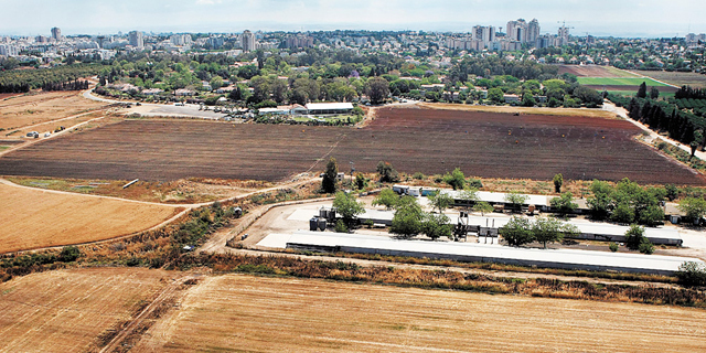 קיבוץ גליל ים ושטחי החקלאות שלו עם הרצליה ברקע 