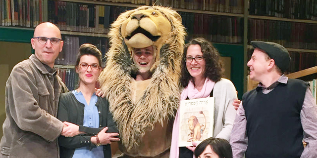 פנאי מישל קנודסן אוחזת ב ספר “אריה הספריה” בעברית עם צוות ההצגה בישראל