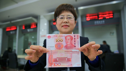 בנקאית סינית מחזיקה יואן, צילום: גטי אימג