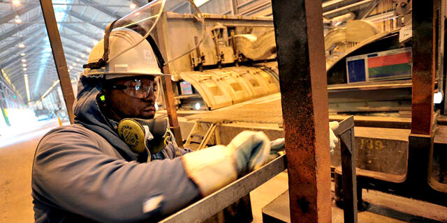 פועל במפעל של אלקואה, צילום: בלומברג