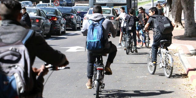 נערים רוכבים על אופניים חשמליים ב דרך ל בית ספר ב פתח תקוה