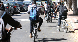 נערים רוכבים על אופניים חשמליים ב דרך ל בית ספר ב פתח תקוה