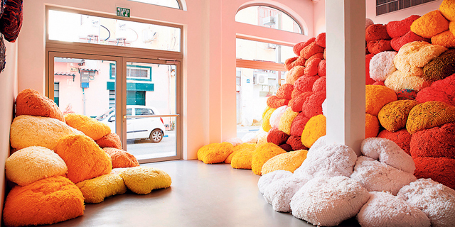 פנאי מיצב Saffron Sentinel בתערוכה ערמות צבעוניות של סיבי פיגמנט אורגני