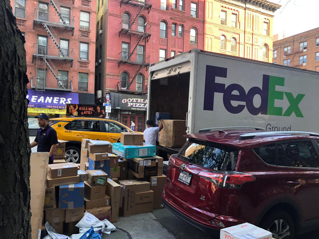 משאית פדקס פורקת חבילות בניו יורק זירת הנדל"ן