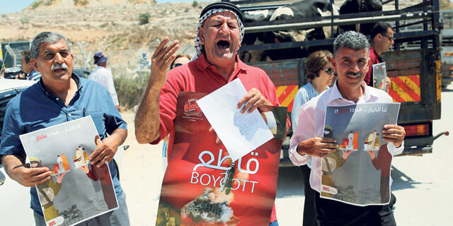 פלסטינים מפגינים במחסום עופר הישראלי ליד רמאללה