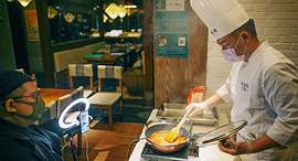 שף עטוי מסכה בעיר טיניאן ב סין מעביר שיעור בישול מקוון ב מסעדה ריקה פנאי