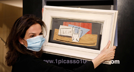 מארגנת ההגרלה פרי קוצ'ין עם הציור Nature Morte של פיקאסו