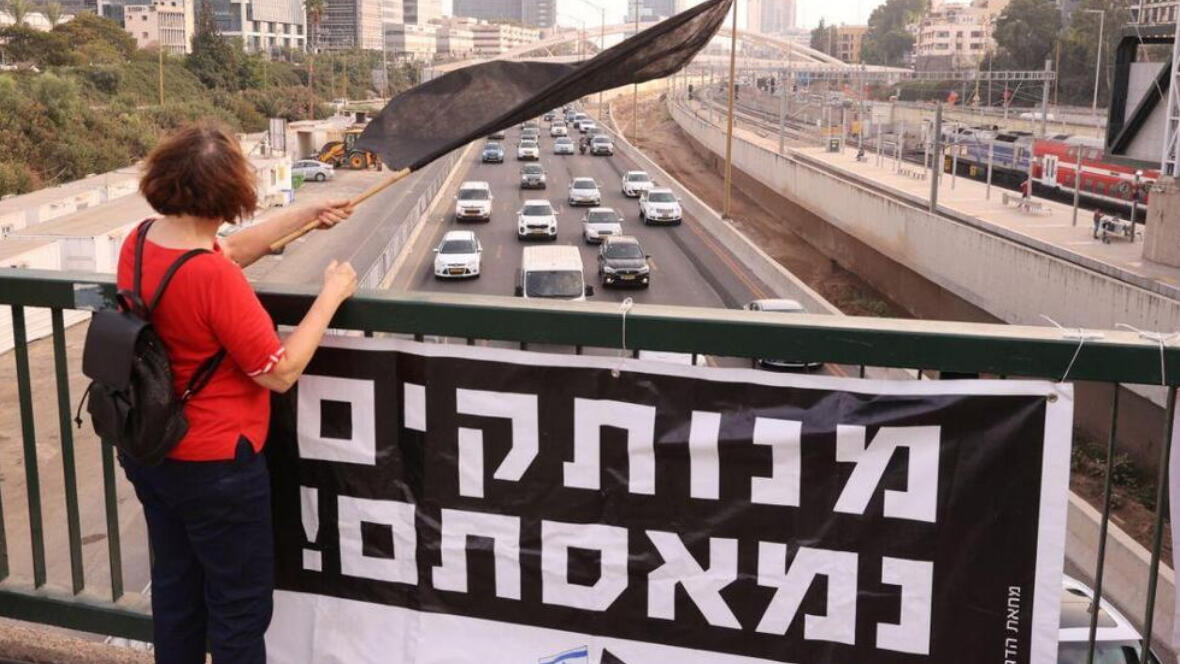 מפגינה מחאת הדגלים השחורים בגשר השלום
