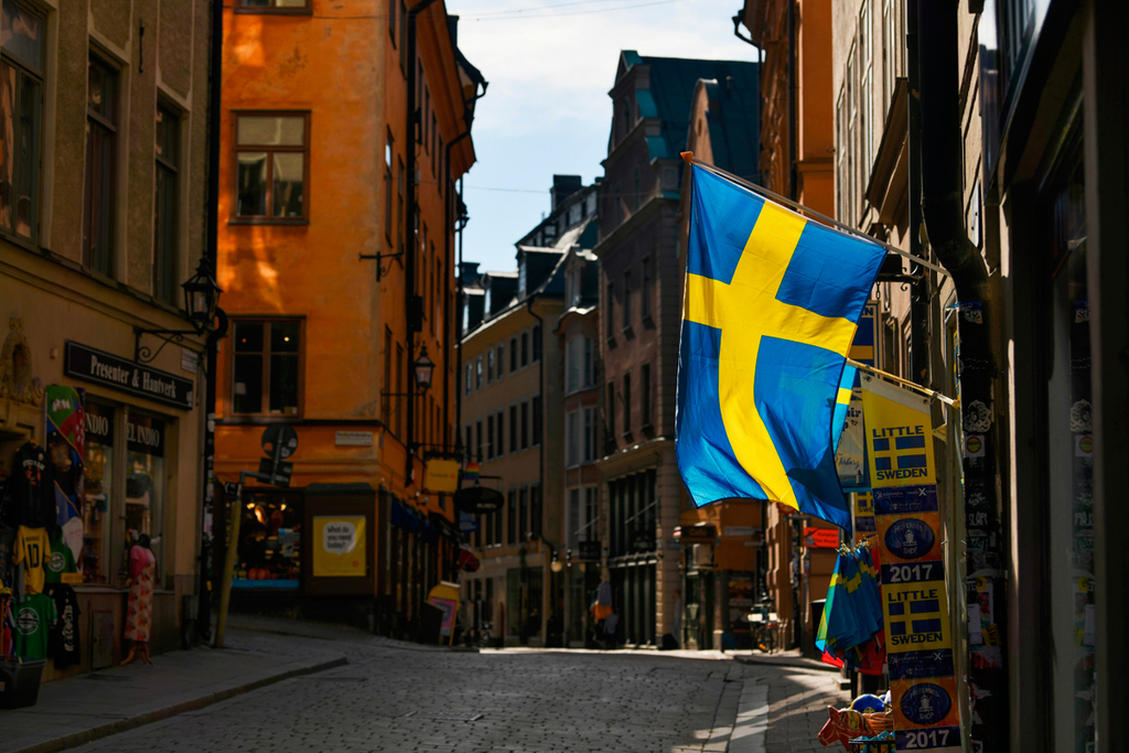 דגל שבדיה מתנופף מחנות מזכרות תיירותית בגמלא סטן בשטוקהולם