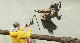 ילדה מתעטשת ציור קיר של הצייר אמן בנקסי פנאי