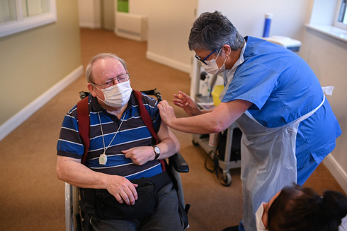 אדם מקבל מנת חיסון של אסטרזניקה בבריטניה, צילום: איי אף פי