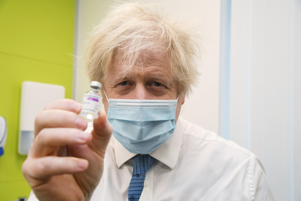 בוריס ג'ונסון ראש ממשלת בריטניה עם בקבוק חיסון אסטרזניקה 15.2.21