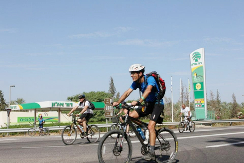 רוכבי אופניים על רקע תחנת דלק דור אלון , צילום: פטריסיה בן עזרא