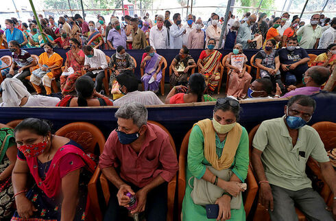 אנשים מחכים בתור לקבלת חיסון לקורונה במומבאי, רויטרס