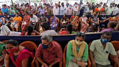 אנשים מחכים בתור לקבלת חיסון לקורונה, מומבאי, הודו, רויטרס