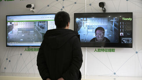 אזרח סיני ממתין לזיהוי פנים. דוגמה ומופת לדמוקרטיה תוססת, צילום: בלומברג