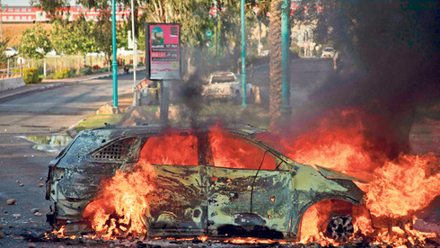 רכב עולה באש בעימותים בלוד, צילום: איי אף פי