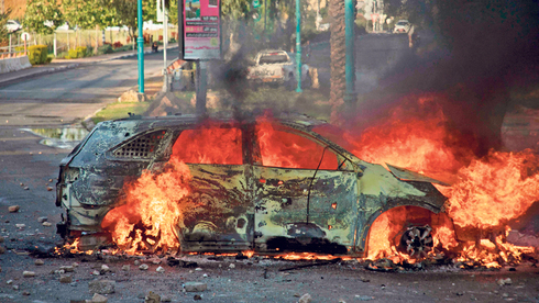 רכב עולה באש בעימותים בלוד, בשבוע שעבר. "להשפיע על קצב ריפוי החברה", צילום: איי אף פי