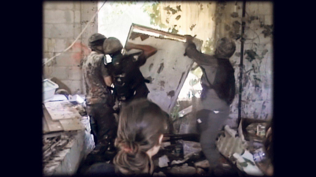 פנאי יהודית כהנא בגבה למצלמה מול חיילים מתוך הסרט