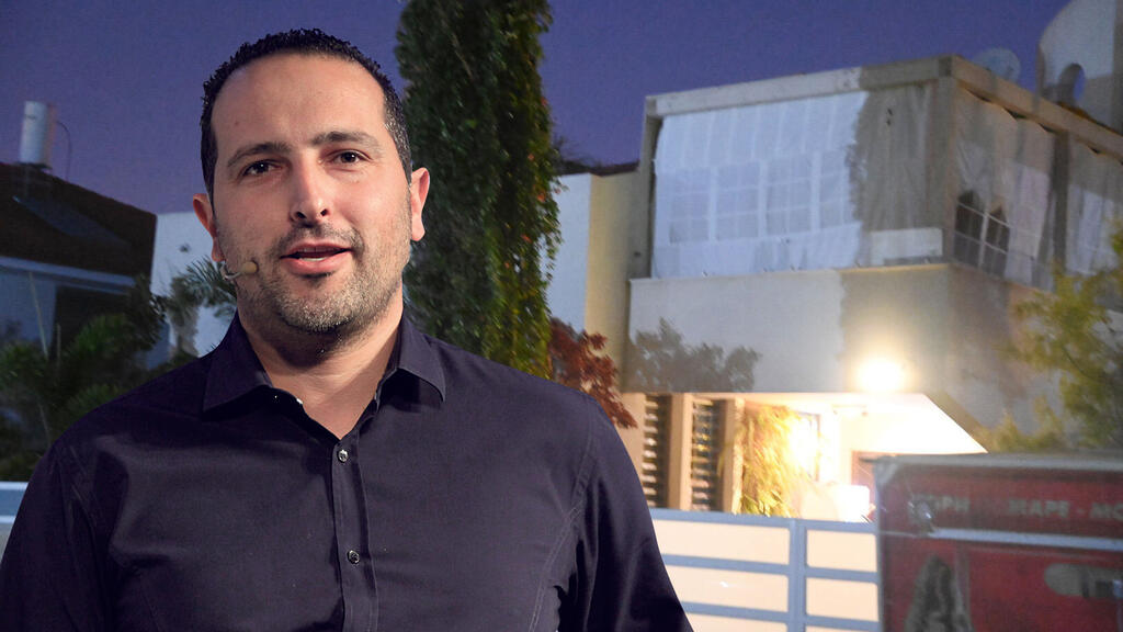 אלדד פרי על רקע הבית שלו