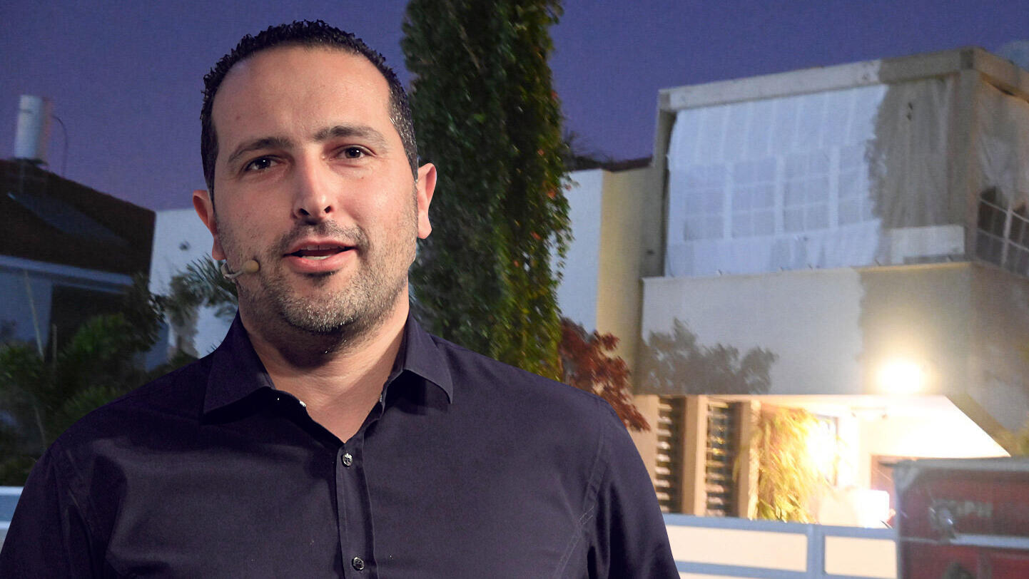 אלדד פרי על רקע הבית שלו