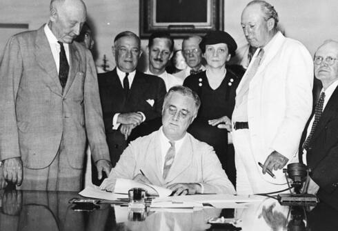 רוזוולט (במרכז) חותם על חקיקה ב-1935, צילום: Wikimedia