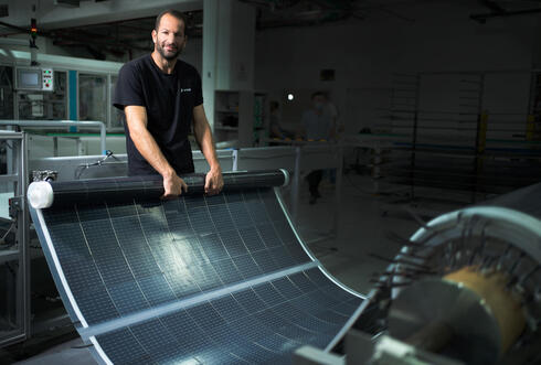 עודד רוזנברג מנכ"ל אפולו פאוור עם יריעה סולארית שמייצרת החברה, צילום: רמי זנגר