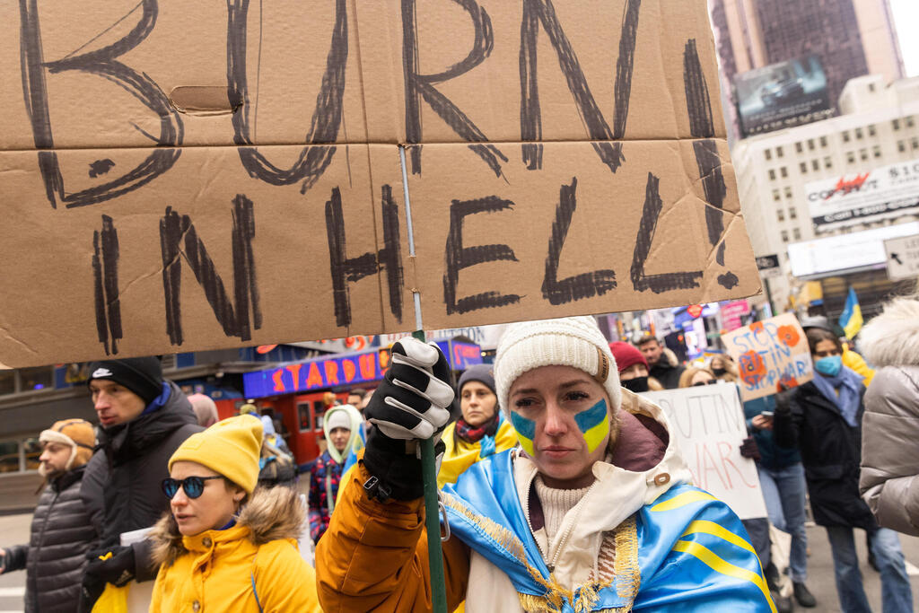 מפגינים נגד פוטין בניו יורק נושאים את השלט עם הכיתוב "תישרף בגיהנום"