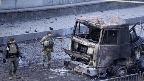 חיילים בוחנים רכב שנפגע בקייב, צילום: AP
