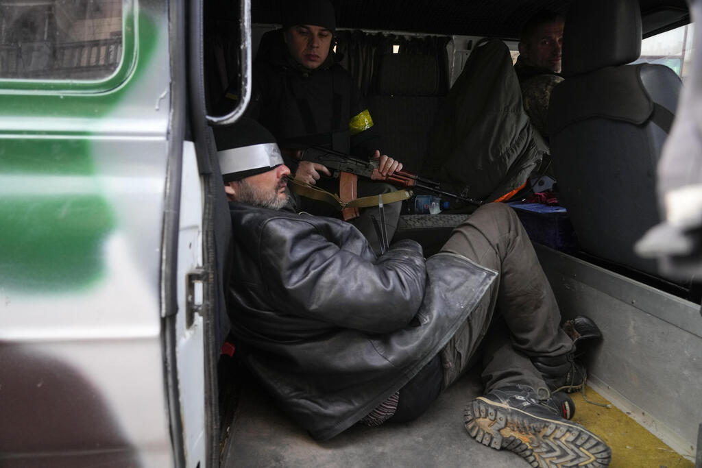 חיילים אוקראיניים מחזיקים אדם שחשדו שהוא מרגל רוסי ב קייב אוקראינה