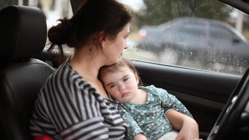 אישה אוקראינית ותינוק ממתינים בפקק בדרך לפולין, צילום: AFP