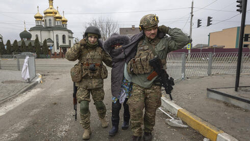 חיילים אוקראינים עוזרים לאישה זקנה באירפין, אוקראינה, צילום: AP