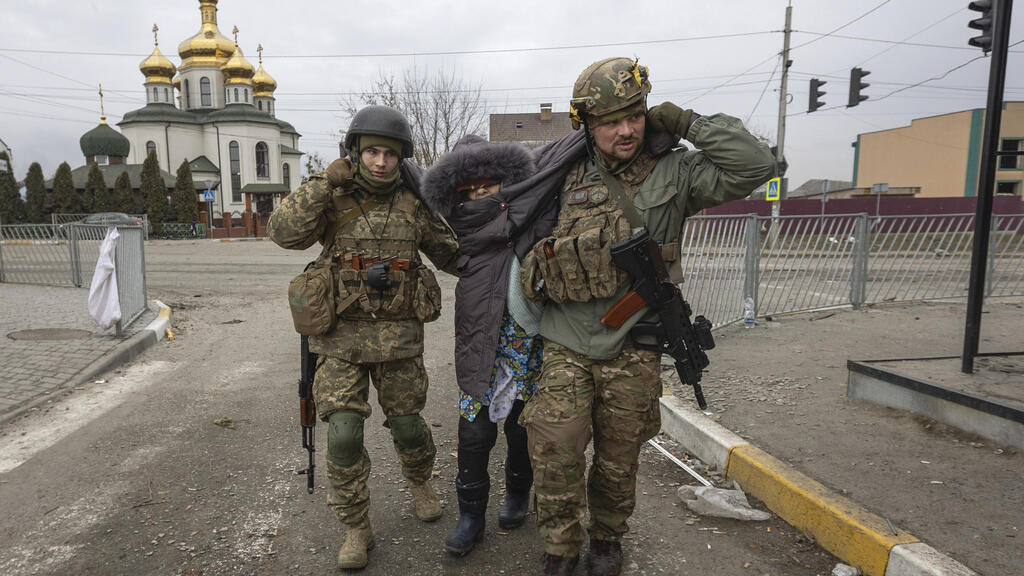 חיילים אוקראינים עוזרים לאישה זקנה ב אירפין אוקראינה