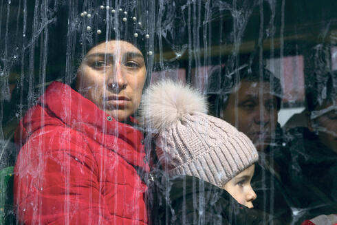 משפחה מלבוב על אוטובוס במעבר הגבול בפולין. פליטים הם האייקון של המלחמה באוקראינה
, צילום: גטי