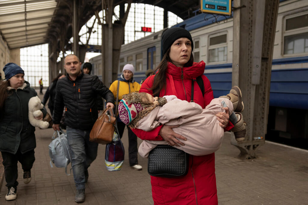 פנאי פליטים אוקראינים ממהרים לעלות על רכבת ל פולין