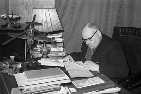 ניקולאי קאמוב ושולחן העבודה שלו, עליו דגם האוטוג