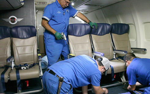 טכנאים מתקינים כיסאות בקבינה של מטוס נוסעים, צילום: AP