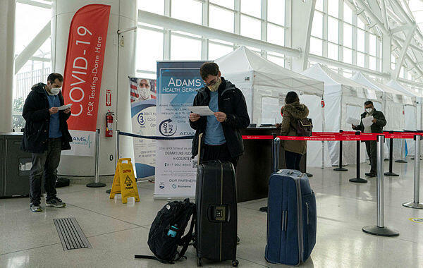 תיירים נכנסים לארה"ב בוחנים תוצאות של בדיקת קורונה בנמל התעופה JFK בניו יורק, צילום: AFP