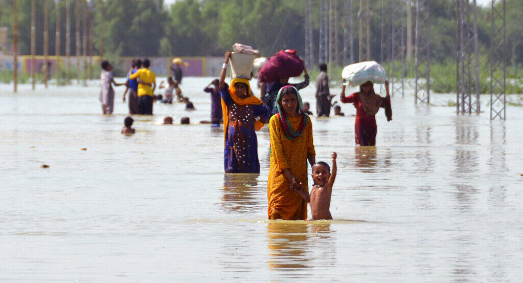פוטו הצפות פקיסטן משפחות צועדות במים 