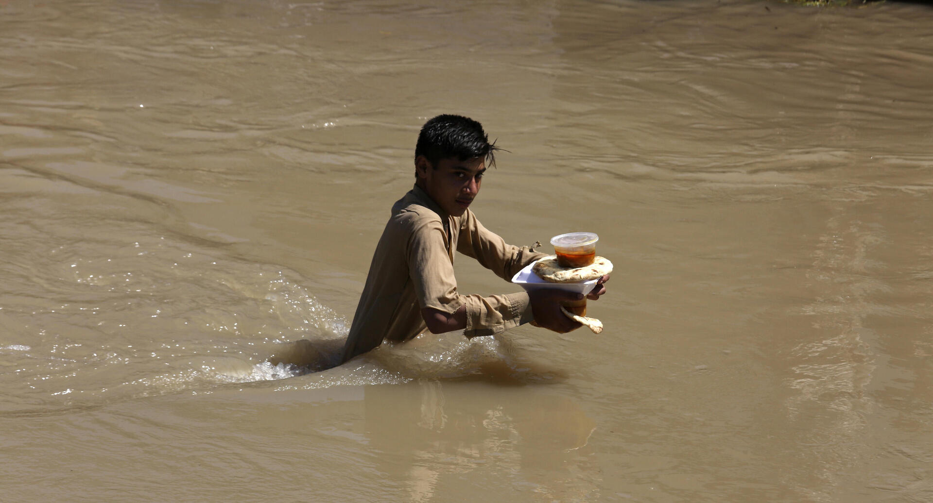 פוטו הצפות בפקיסטן ילד עם מזון 