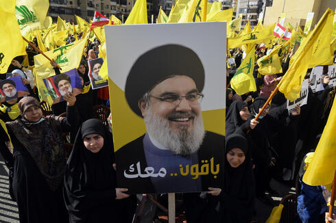Hezbollah supporters with sign featuring their leader Hassan Nasrallah  